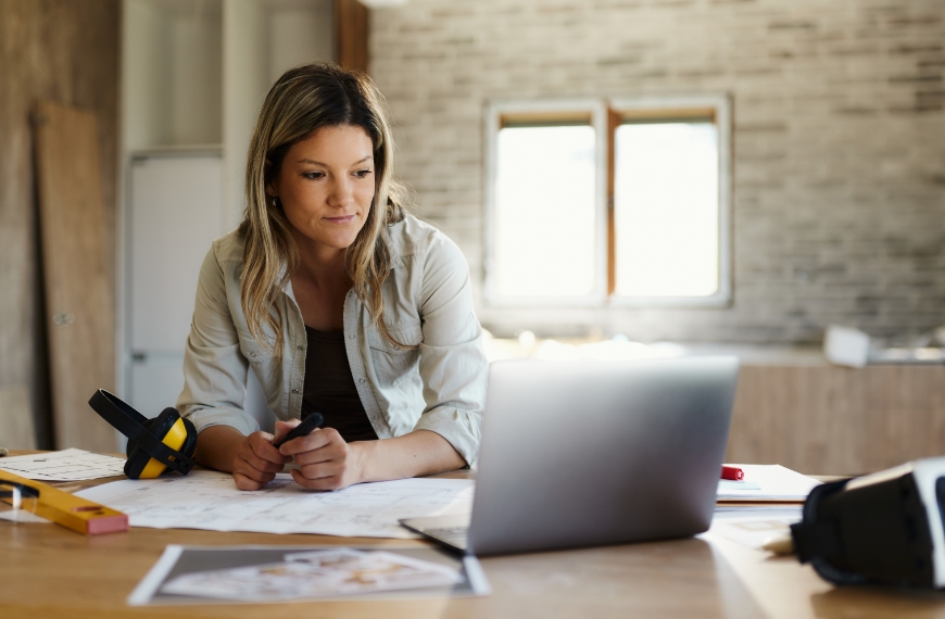 A home services business owner in a workshop using a laptop